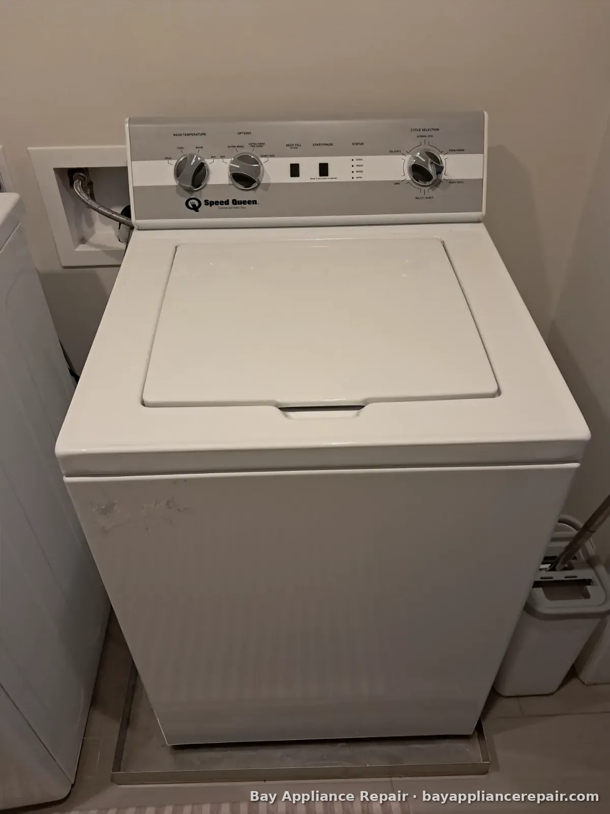 White top-load washer with control knobs