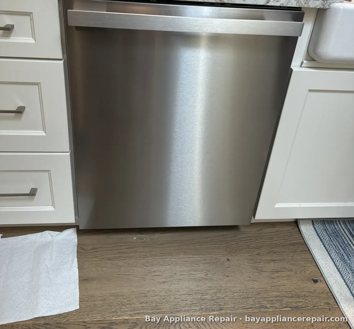 Stainless steel dishwasher installed under a granite countertop