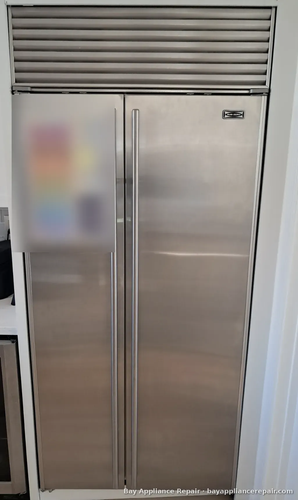 Sub-Zero built-in side-by-side refrigerator with stainless doors and top grille