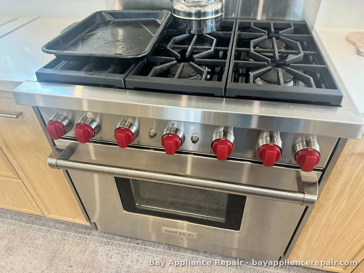 Wolf range with red knobs and a stainless steel oven door